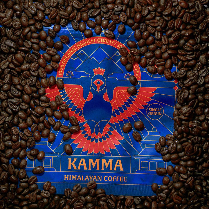 Kamma Himalayan Coffee packaging surrounded by coffee beans