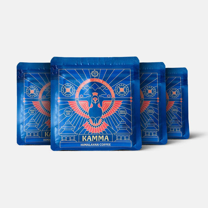 Four blue packages of Kamma Himalayan Coffee on a white background
